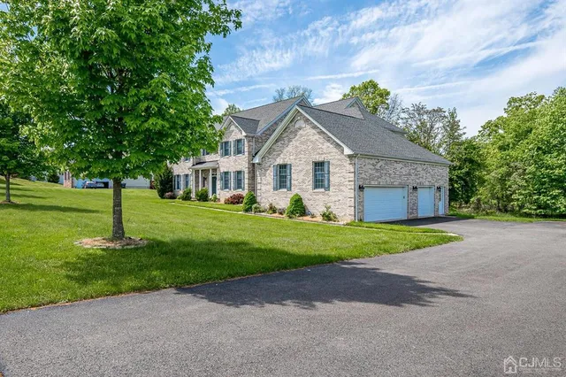 a front view of a house with a yard and trees