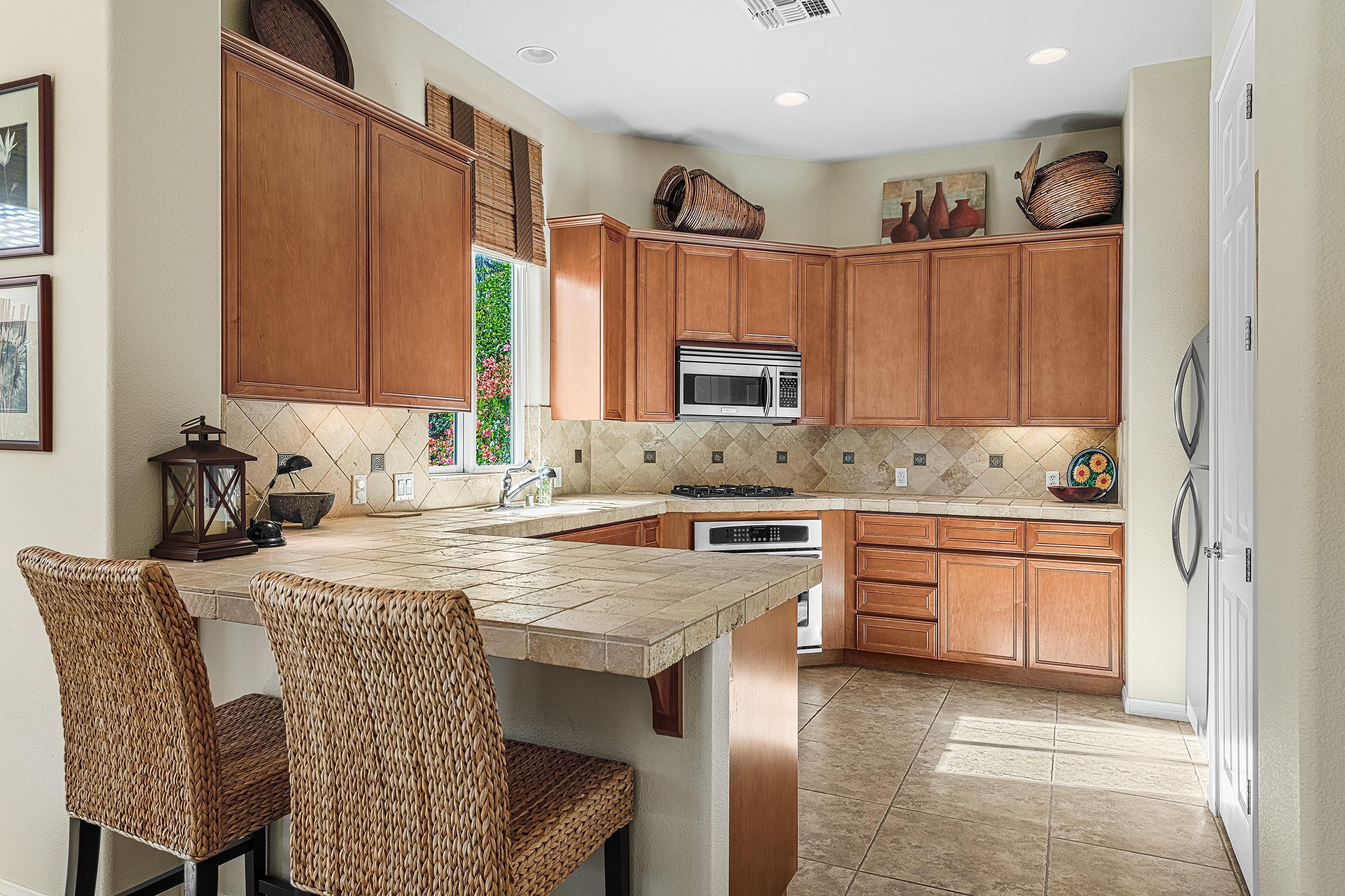 80921 Calle Azul La Quinta, CA 92253 - Photo 11 of 42 a kitchen with granite countertop a sink stove and cabinets