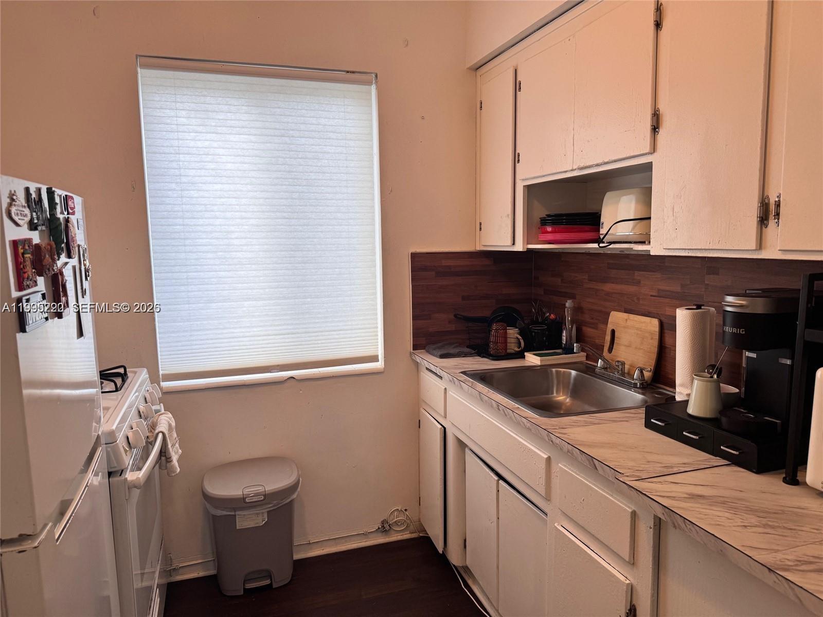 7440 Byron Avenue, Unit 12B Miami Beach, FL 33141 - Photo 4 of 22 a kitchen with a sink and a stove next to a window
