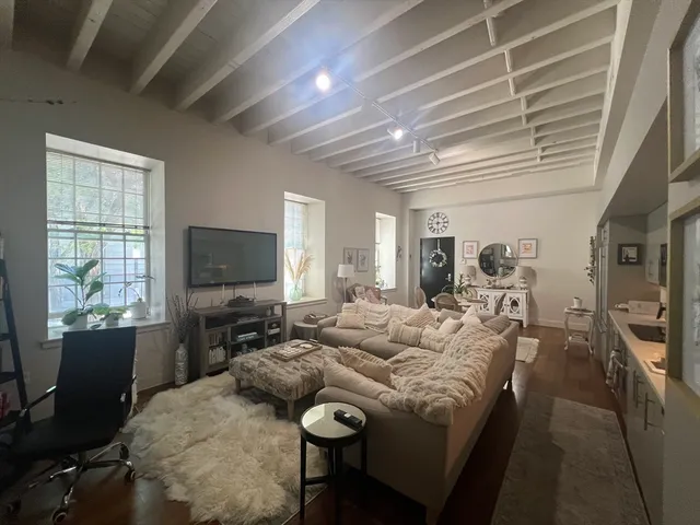 a living room with furniture a flat screen tv and a large window