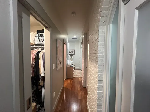 a view of a hallway with wooden floor and stairs