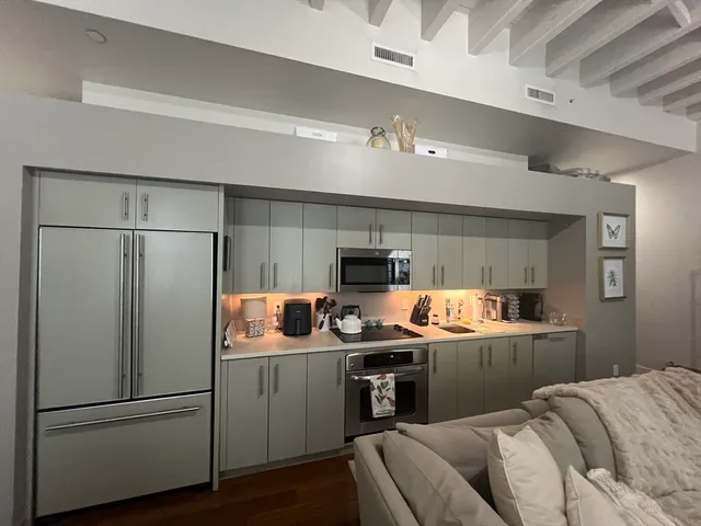 a kitchen with stainless steel appliances granite countertop a refrigerator and a stove