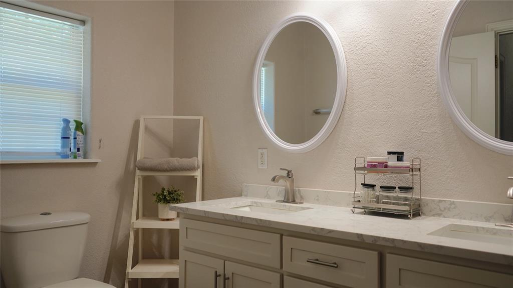 421 Weakes Street Eustace, TX 75124 - Photo 13 of 40 a bathroom with a toilet a sink and a mirror