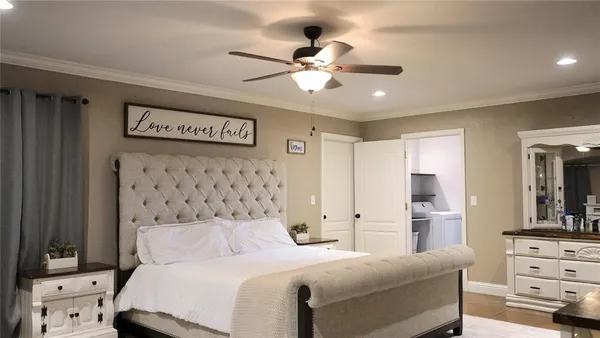 a bedroom with a large bed and a chandelier