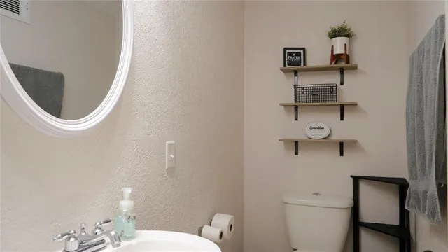 a bathroom with a toilet and a mirror