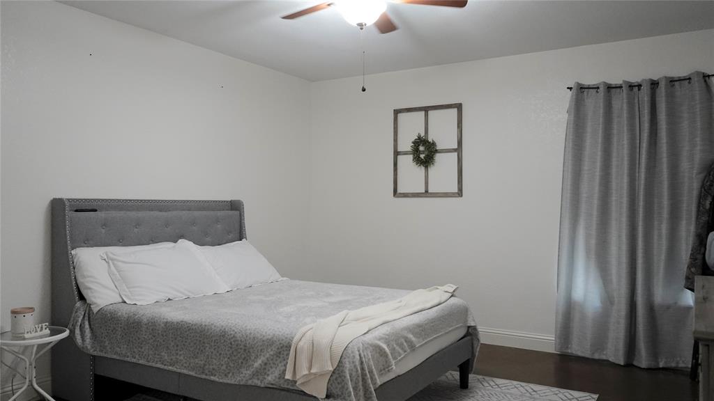 421 Weakes Street Eustace, TX 75124 - Photo 26 of 40 a bed sitting in a bedroom next to a lamp