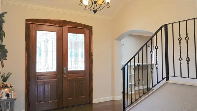 a view of staircase with railing and a chandelier