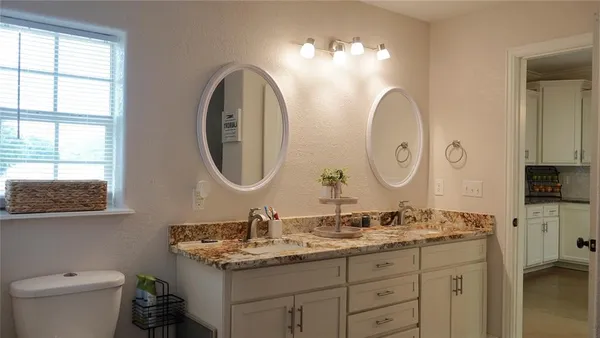 a bathroom with a granite countertop double vanity sinks and a mirror