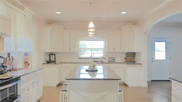 a kitchen with granite countertop a sink stainless steel appliances and cabinets