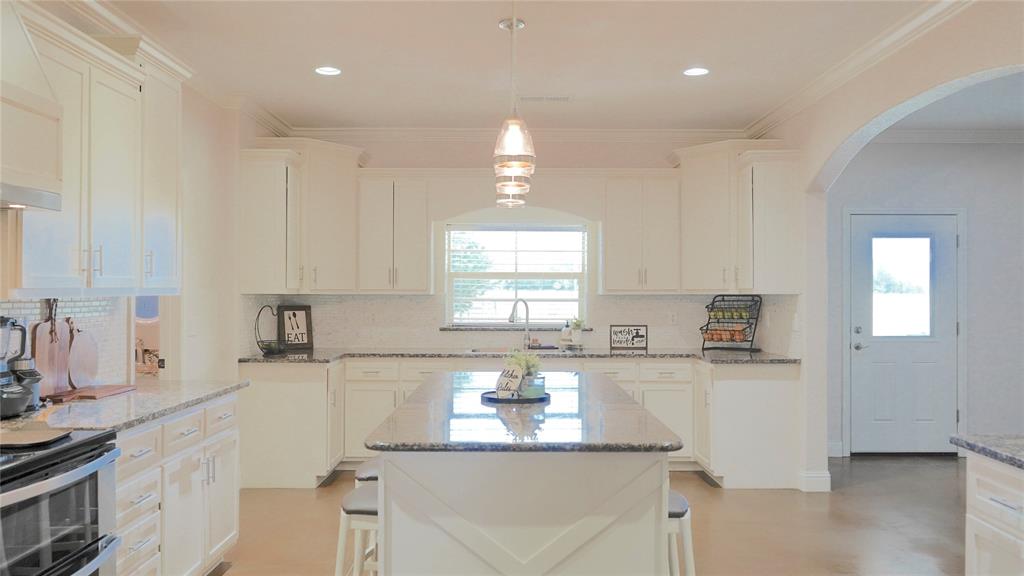 421 Weakes Street Eustace, TX 75124 - Photo 33 of 40 a kitchen with granite countertop a sink stainless steel appliances and cabinets