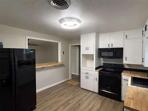 a kitchen with a refrigerator and a stove top oven