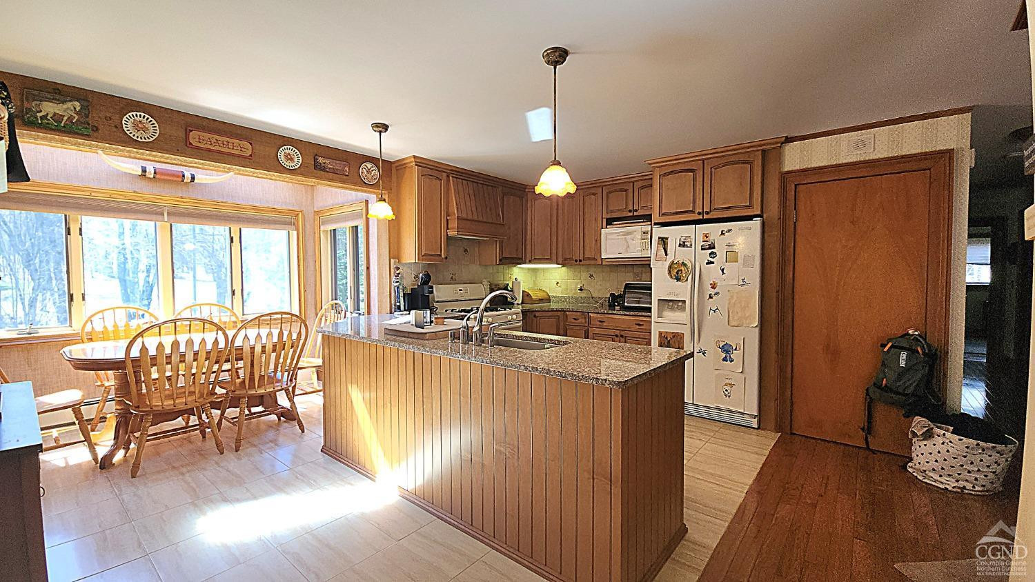 159 Toles Hollow Road Conesville, NY 12076 - Photo 13 of 53 a kitchen with stainless steel appliances kitchen island granite countertop a refrigerator a stove and a wooden floors