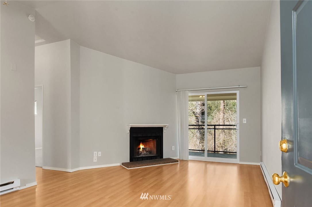 10838 East Riverside Drive, Unit C301 Bothell, WA 98011 - Photo 4 of 23 a view of an empty room with a fireplace and a window