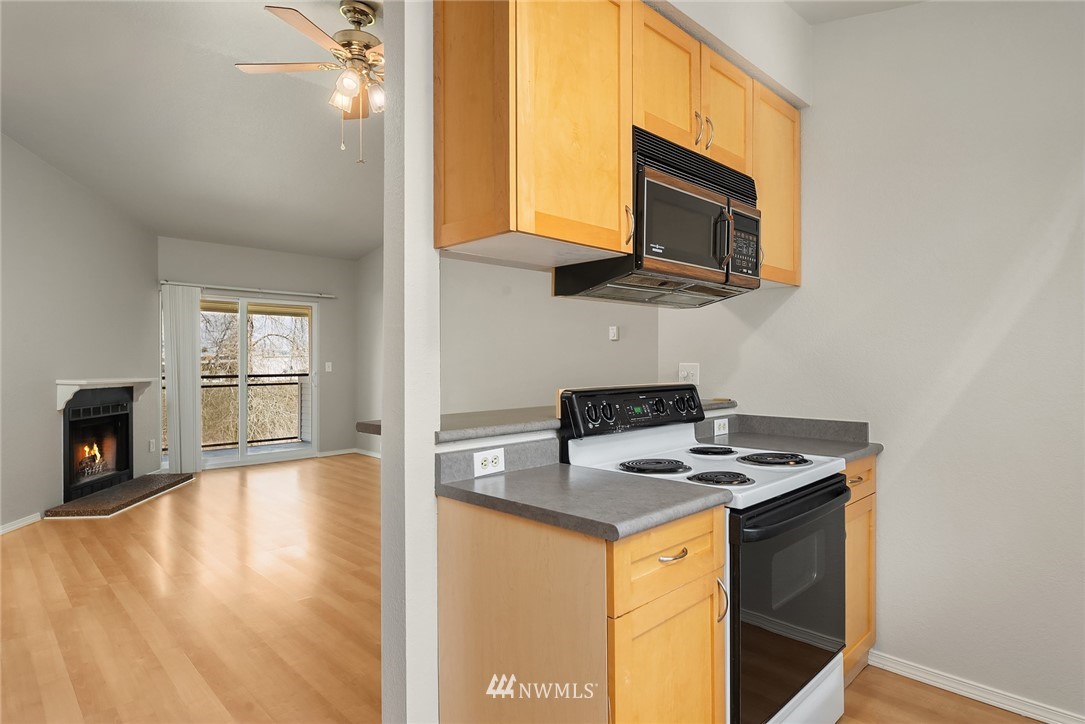10838 East Riverside Drive, Unit C301 Bothell, WA 98011 - Photo 6 of 23 a kitchen with stainless steel appliances a stove microwave and sink