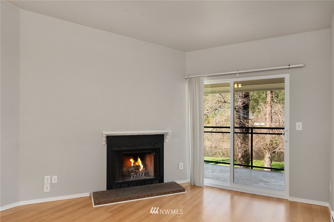 10838 East Riverside Drive, Unit C301 Bothell, WA 98011 - Photo 8 of 23 a view of an empty room with wooden floor and a window