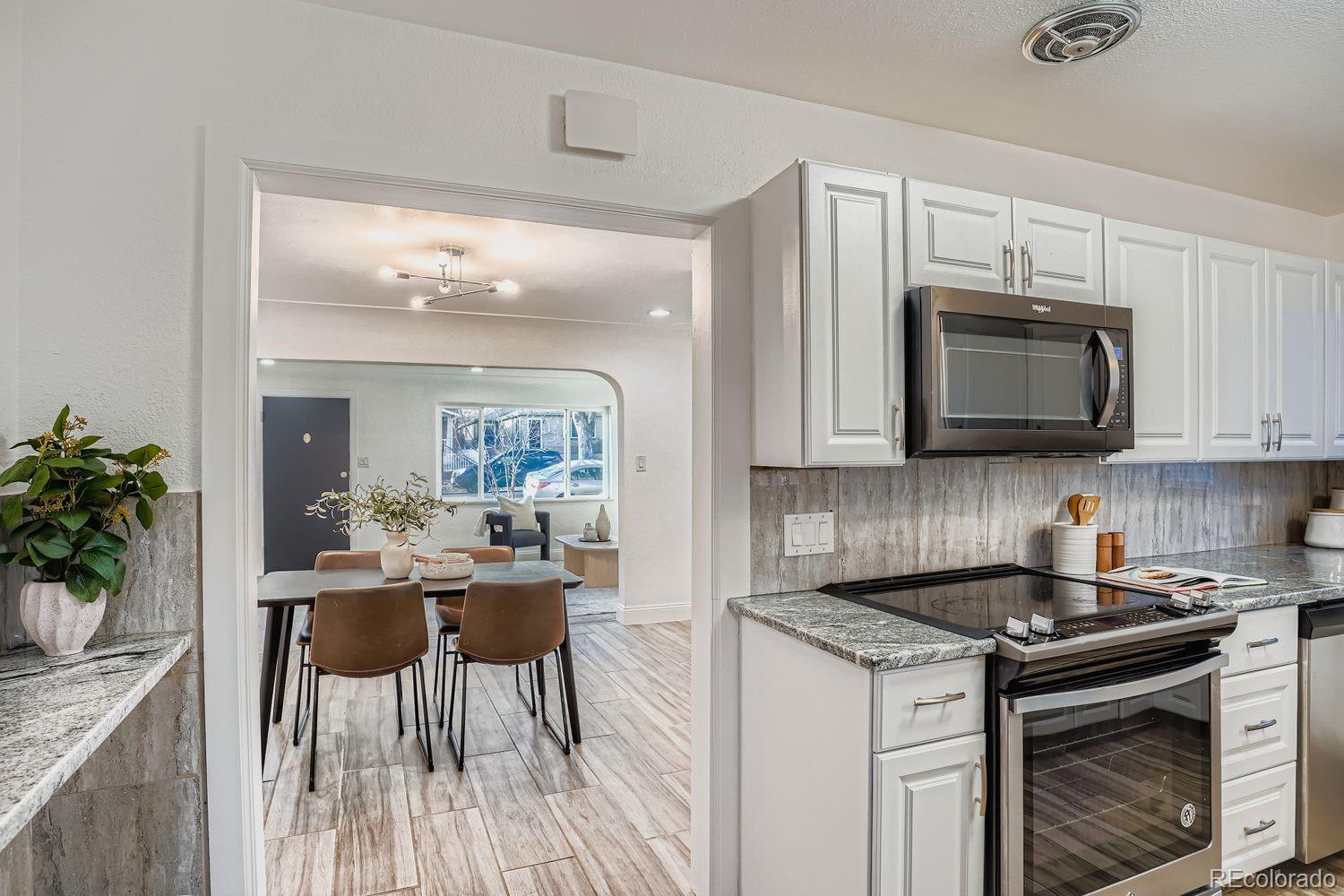3822 Julian Street Denver, CO 80211 - Photo 13 of 28 a kitchen with stainless steel appliances granite countertop a stove a sink and a microwave