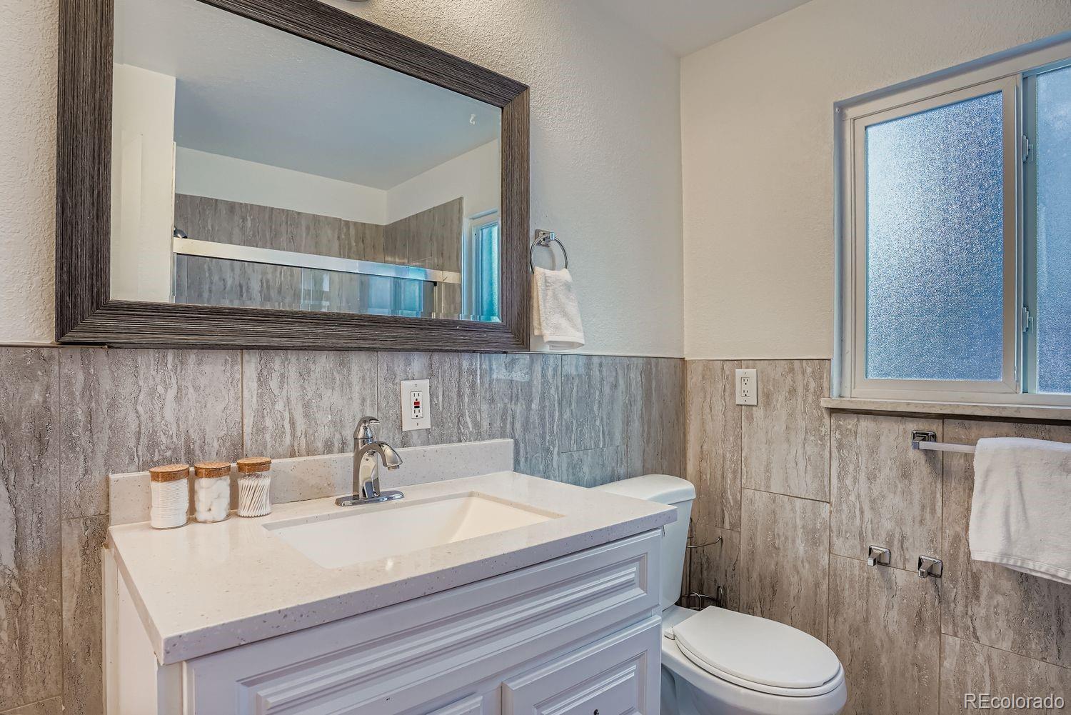 3822 Julian Street Denver, CO 80211 - Photo 20 of 28 a bathroom with a sink a toilet and a mirror