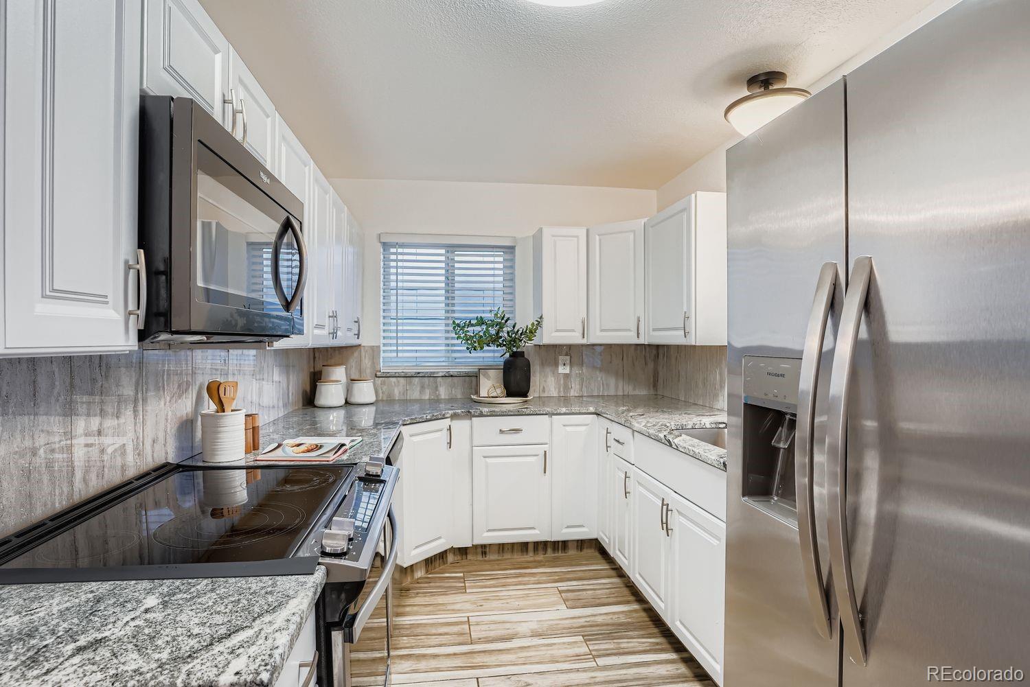 3822 Julian Street Denver, CO 80211 - Photo 10 of 28 a kitchen with stainless steel appliances granite countertop a sink a stove and a refrigerator