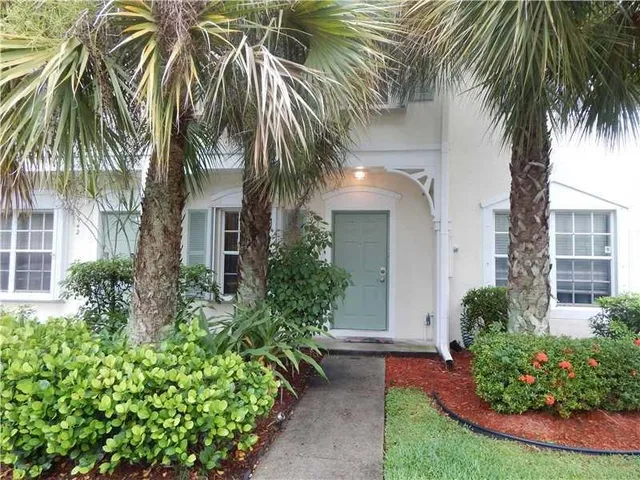 a view of a palm plant that is in front of a house
