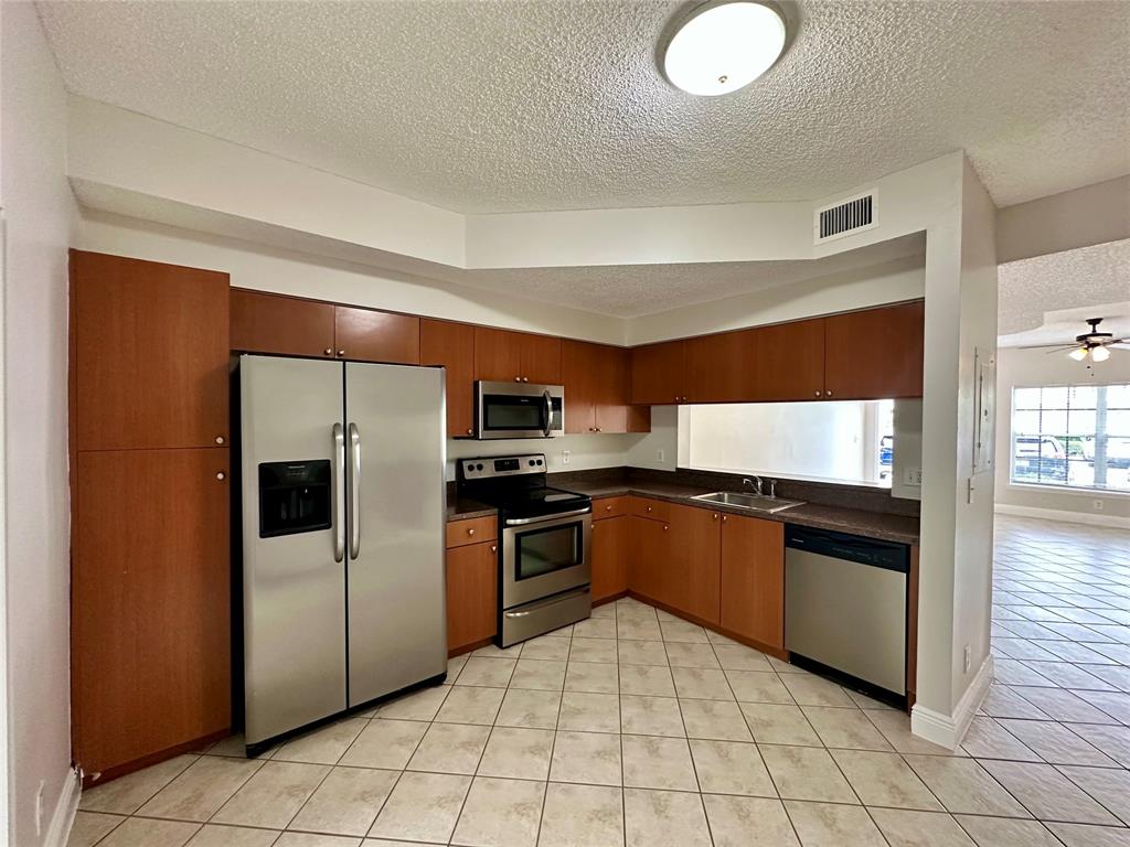 5660 Northwest 98th Way Coral Springs, FL 33076 - Photo 6 of 25 a kitchen with stainless steel appliances granite countertop a refrigerator and a sink