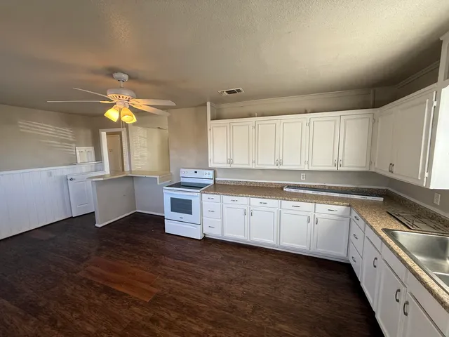 a kitchen with a sink cabinets wooden floor and a window
