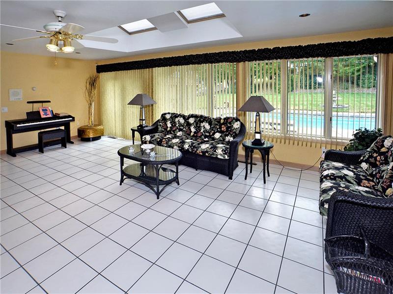 201 Harrison Road Turtle Creek, PA 15145 - Photo 5 of 25 Sun room features 1/2 bath and double sided fireplace