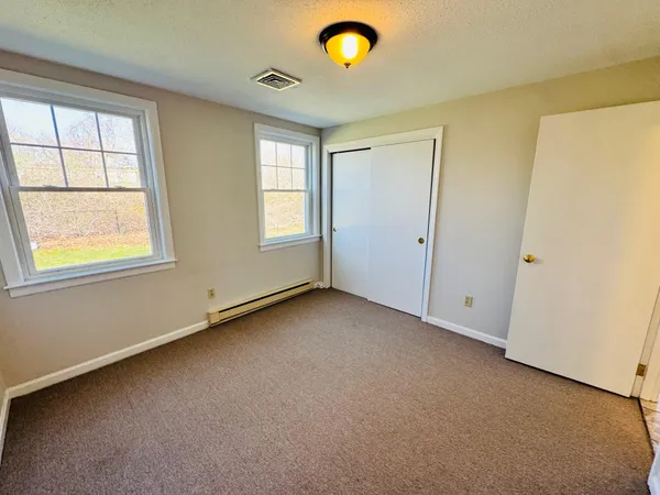 an empty room with windows and closet