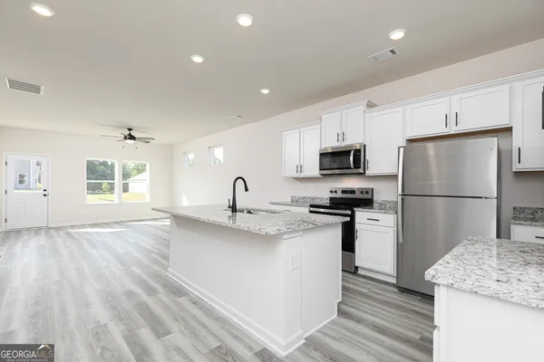 a kitchen with stainless steel appliances granite countertop a refrigerator stove a sink and a refrigerator