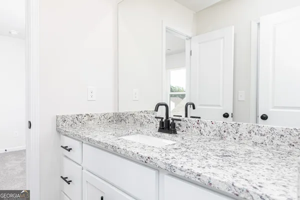 a bathroom with a granite countertop sink and a mirror