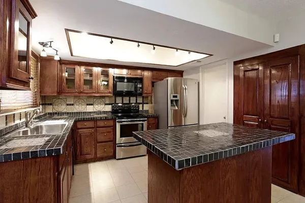a kitchen with stainless steel appliances granite countertop a sink stove and refrigerator