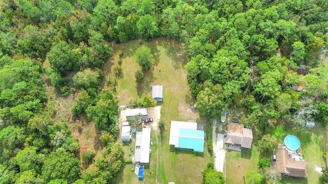 a aerial view of residential houses with outdoor space and trees