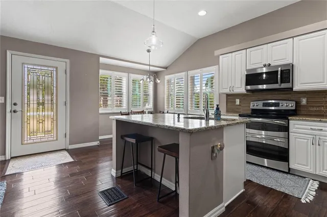 a kitchen with stainless steel appliances granite countertop a stove a sink and a microwave