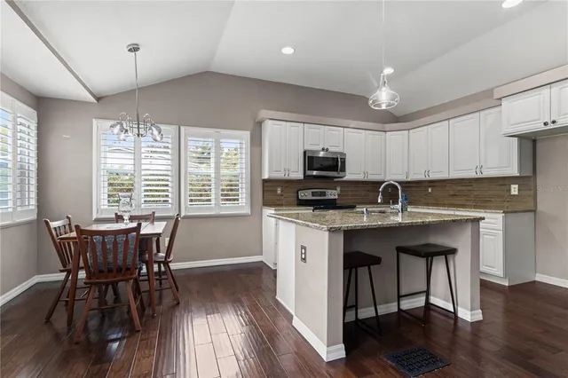 a kitchen with a table chairs stove and microwave