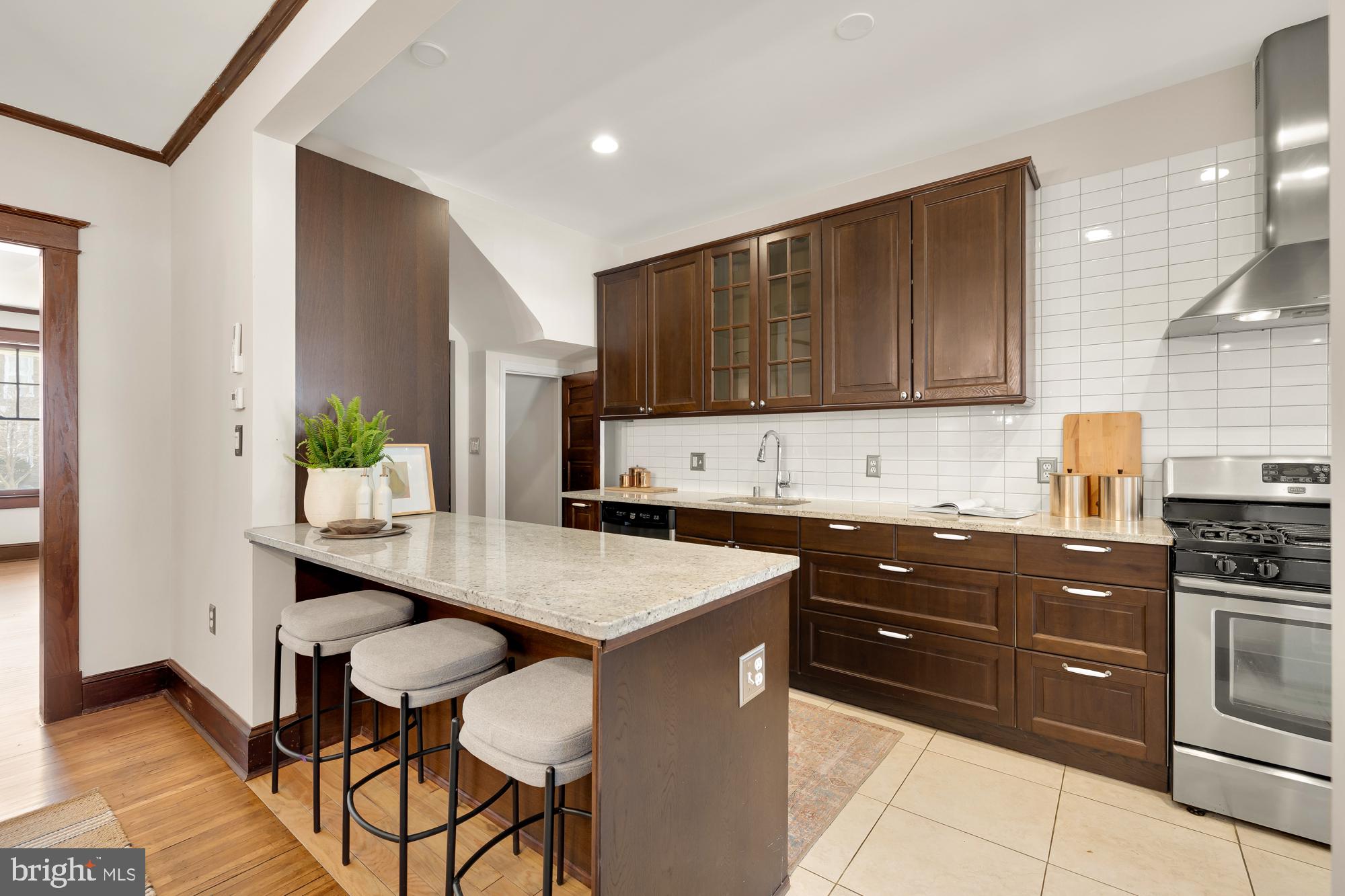 28 Bryant Street Northeast Washington, DC 20002 - Photo 12 of 41 a kitchen with stainless steel appliances kitchen island granite countertop a stove a sink and a refrigerator