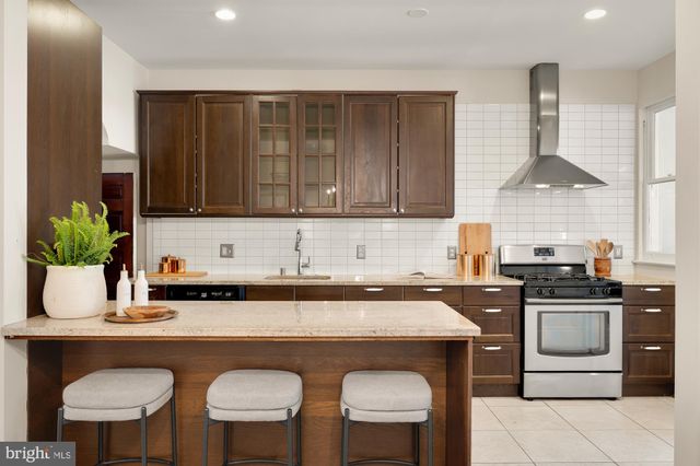 a kitchen with stainless steel appliances granite countertop a stove a sink a microwave and white cabinets