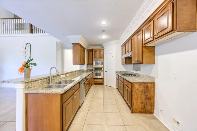 a kitchen with stainless steel appliances granite countertop a sink and a refrigerator