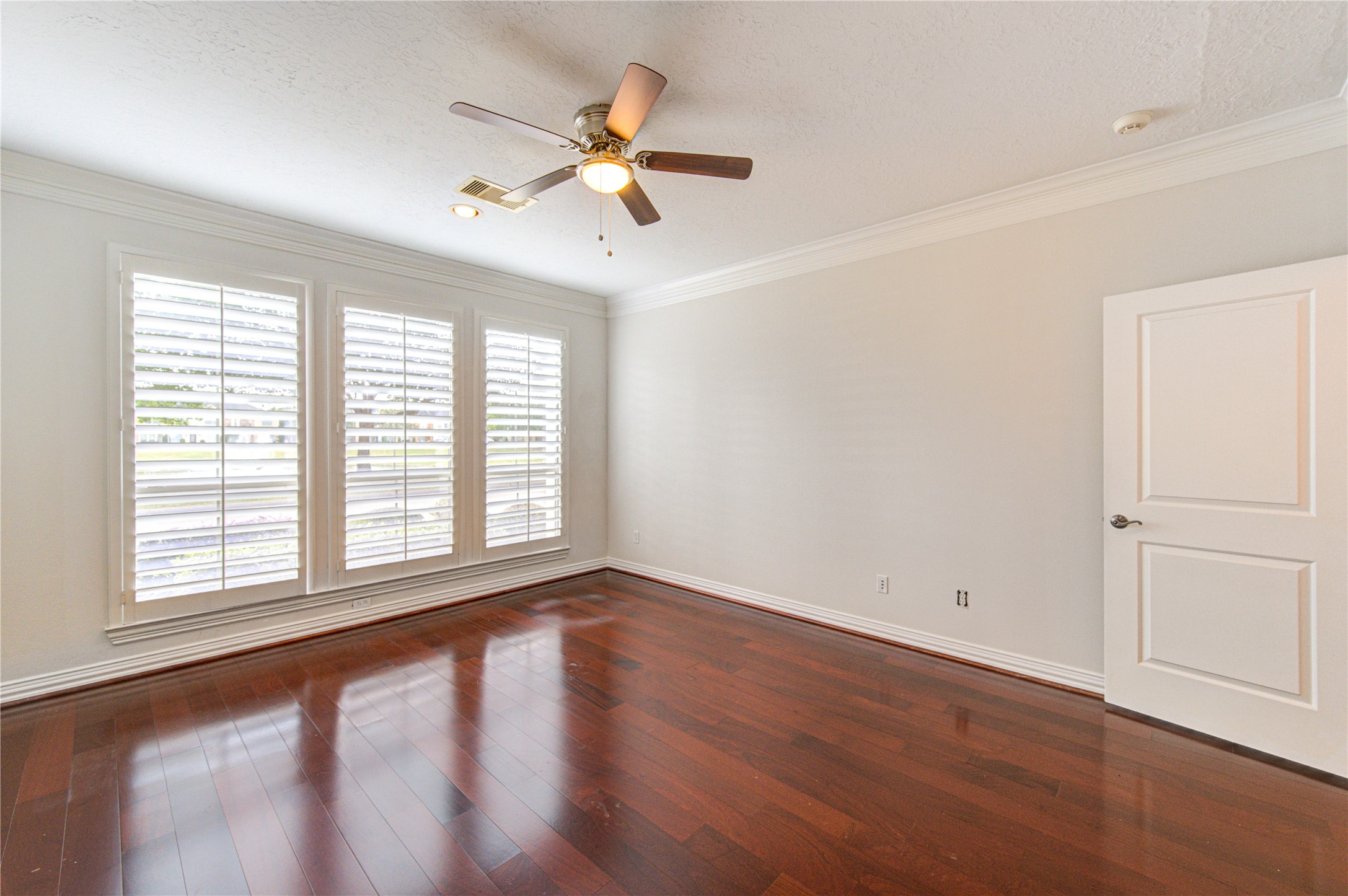 2011 Spring Cedar Lane Houston, TX 77077 - Photo 22 of 43 an empty room with wooden floor fan and windows