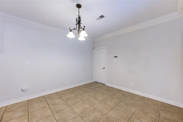 a view of an empty room with a chandelier fan
