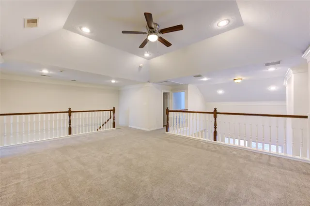 an empty room with ceiling fan and windows