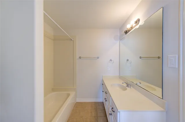 a bathroom with a tub sink and mirror