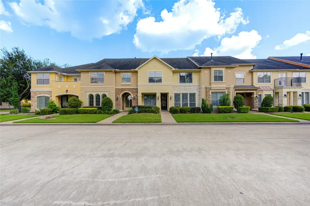 a view of a big house with a big yard and large trees