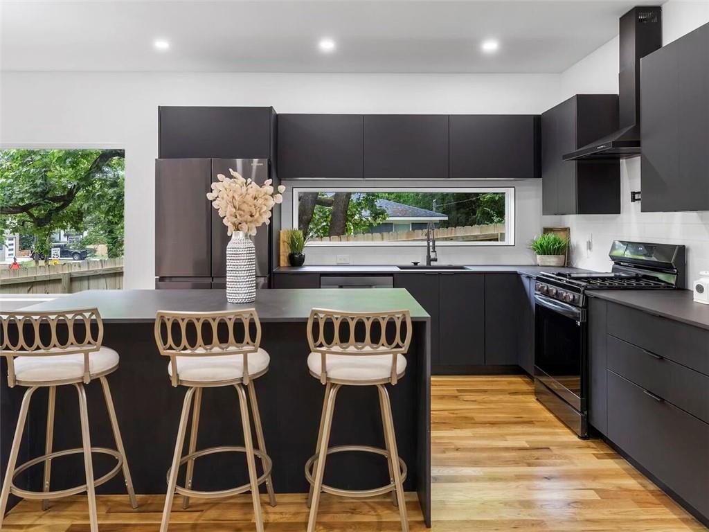 1065 Hubbard Street Southwest Atlanta, GA 30310 - Photo 8 of 20 a kitchen with stainless steel appliances kitchen island granite countertop a table and chairs in it