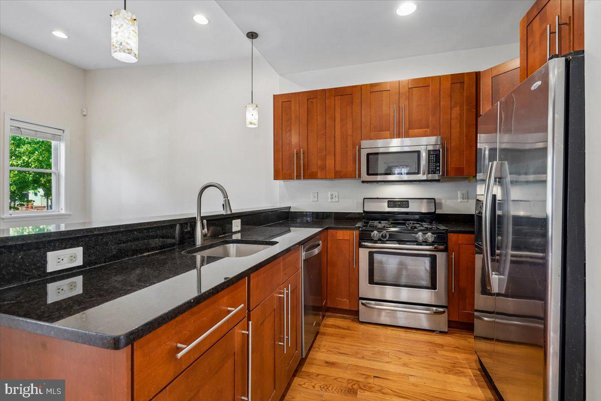 1339 C Street Northeast Washington, DC 20002 - Photo 10 of 24 a kitchen with stainless steel appliances granite countertop a sink stove and microwave