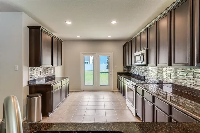a kitchen with stainless steel appliances granite countertop wooden cabinets a stove top oven a sink and dishwasher