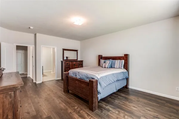 a bed sitting in a spacious bedroom next to a window