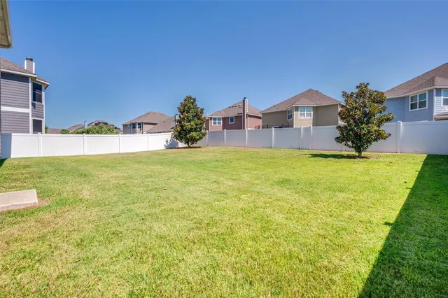 a view of a house with a yard and a tree