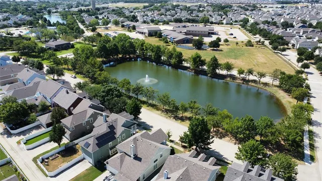 an aerial view of residential houses with outdoor space and lake view