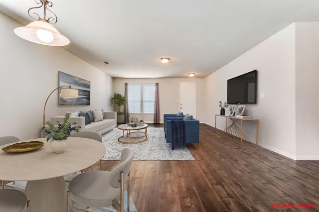a living room with furniture flat screen tv and couches