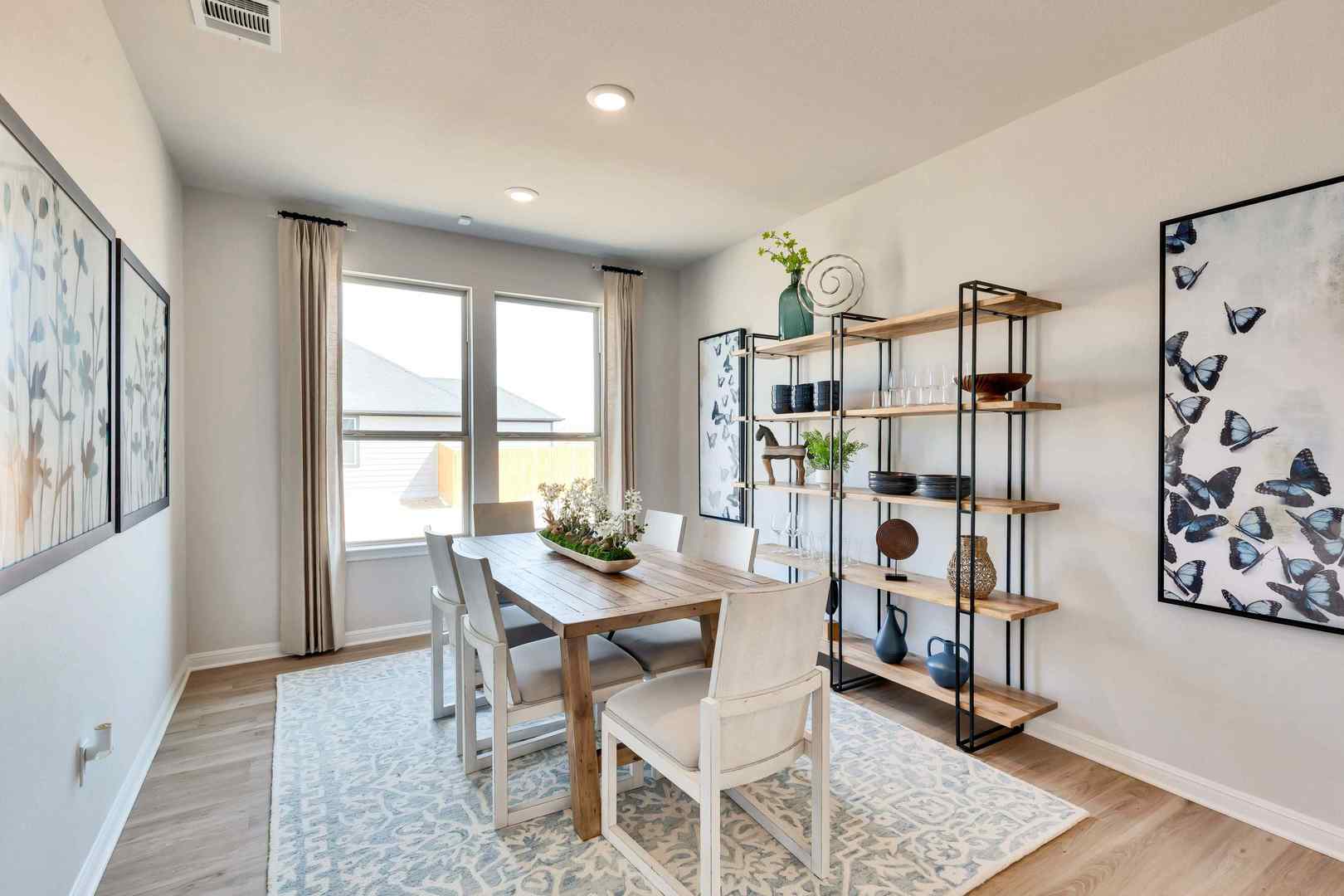 1205 Lavender Way Georgetown, TX 78628 - Photo 4 of 14 Natural light pours into this elegant dining area, boasting sleek wooden flooring and modern shelving.