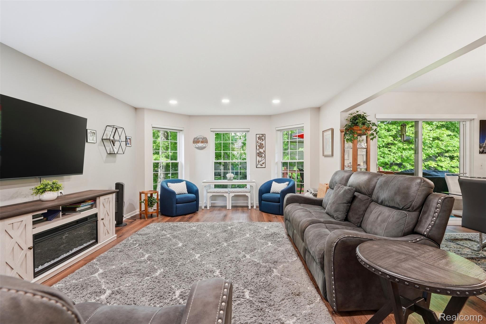 1687 Lodge Pole Lane Rochester, MI 48309 - Photo 6 of 53 Spacious living area featuring wood-finish flooring, recessed lighting, and a built-in entertainment console with an electric fireplace